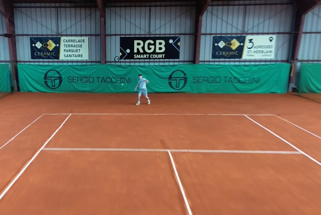 Joueur sur un court couvert en terre battue du club