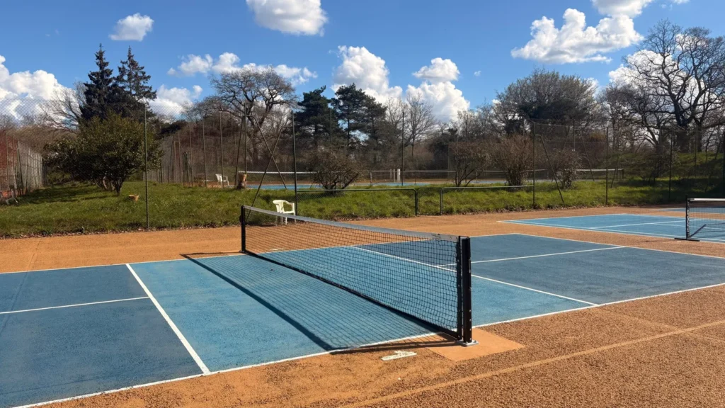 Partie de pickleball en double sur un terrain extérieur du club