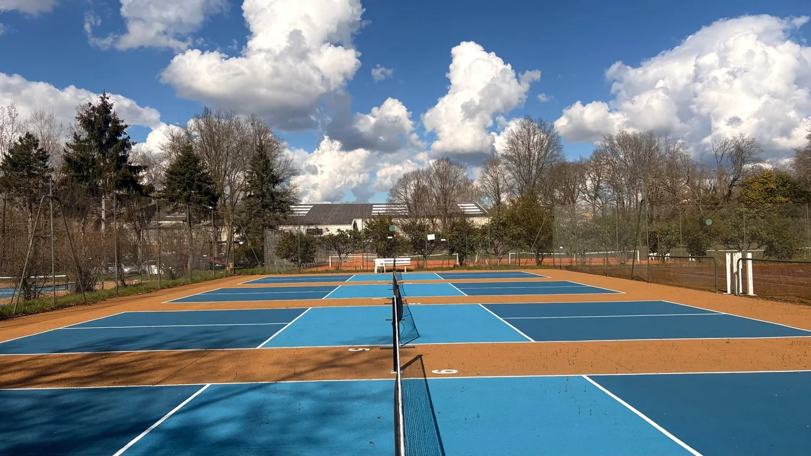 Terrains de pickleball extérieurs du Country Club Nantais sous un ciel bleu