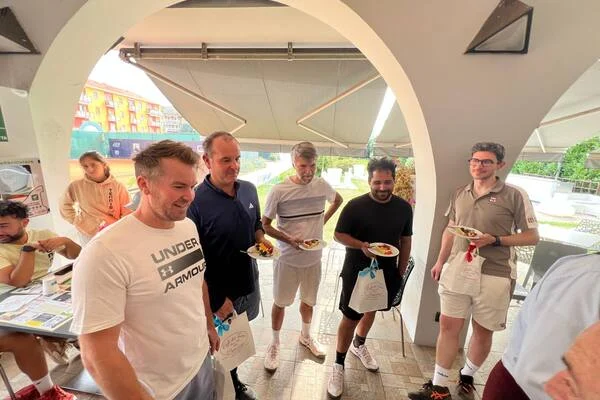 Déjeuner au club de Biella : joueurs du CCN avec leurs assiettes et leurs sacs cadeaux